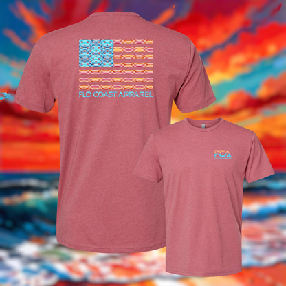 Two heathered pink t-shirts from FLO Coast Apparel shown against a colorful abstract background. The larger shirt shows the back with a stylized American flag made of wavy orange and yellow stripes, with the brand name printed below.