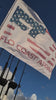 Focus on a Flo Coast Apparel Flag waving and rippling through the open air on a boat